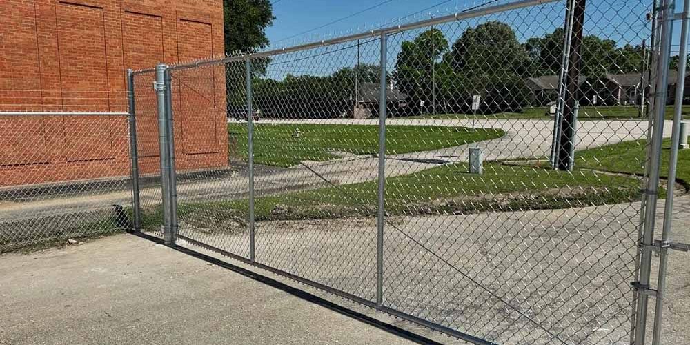Durable chain link driveway installed along a property boundary in Baton Rouge
