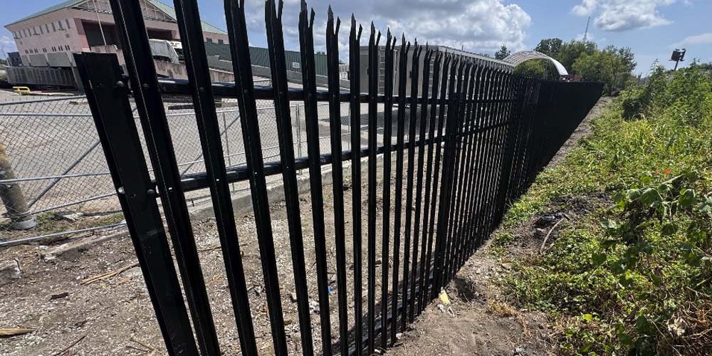 Professional metal fence installation along a property boundary in Baton Rouge